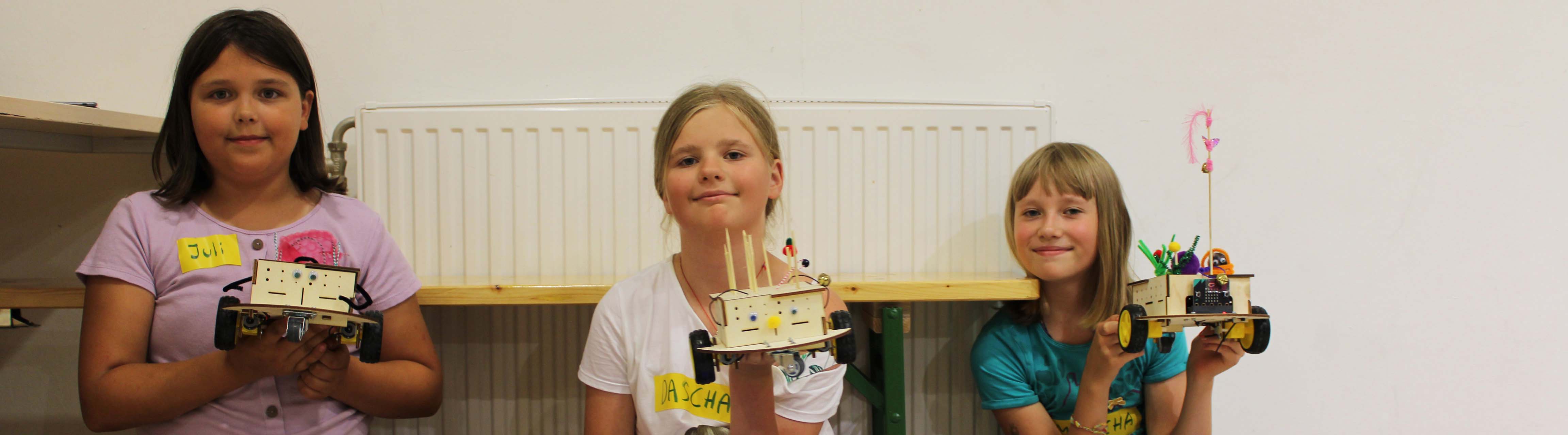 Drei Mädchen mit ihren selbst gebauten Robotern
