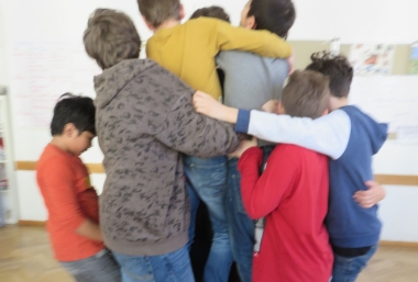 Sieben Kinder umarmen einander. Workshop zur Friedenspädagogik